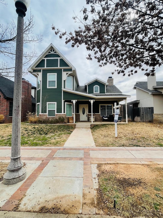 view of front of house featuring covered porch and a front lawn