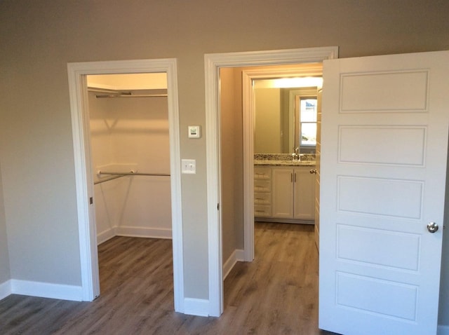 hallway with dark wood-type flooring and sink