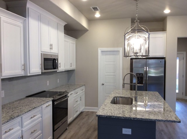 kitchen with stainless steel appliances, a kitchen island with sink, sink, and white cabinets