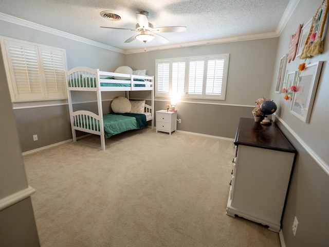 carpeted bedroom with visible vents, a ceiling fan, a textured ceiling, and crown molding