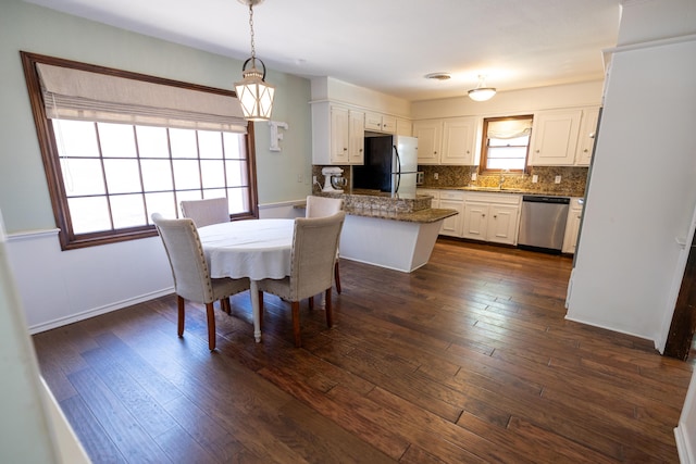 dining space featuring baseboards and dark wood-type flooring
