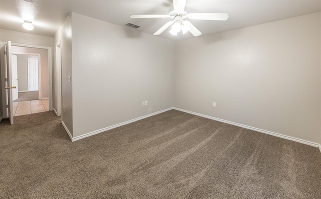 empty room featuring dark colored carpet and ceiling fan