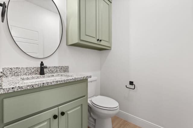 bathroom with hardwood / wood-style flooring, vanity, and toilet