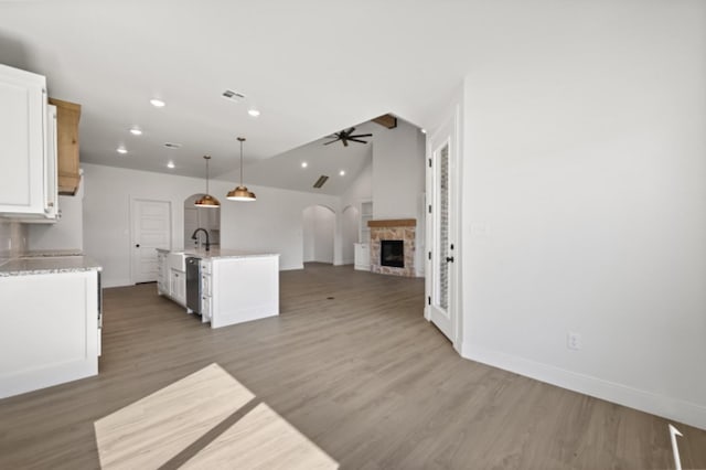 kitchen featuring dark wood-type flooring, dishwasher, ceiling fan, hanging light fixtures, and white cabinets