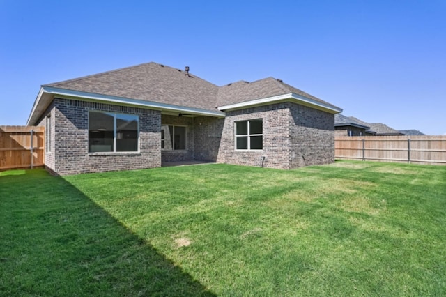 rear view of property featuring a yard