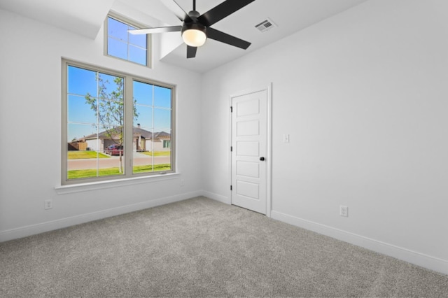 empty room featuring a healthy amount of sunlight, carpet floors, and ceiling fan