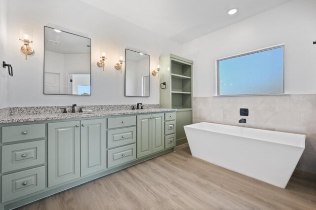 bathroom featuring vanity, a bathing tub, and tile walls