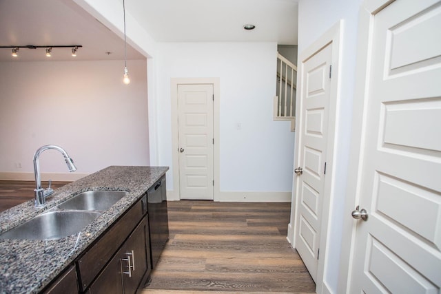 kitchen featuring pendant lighting, sink, dishwasher, dark stone countertops, and dark brown cabinets