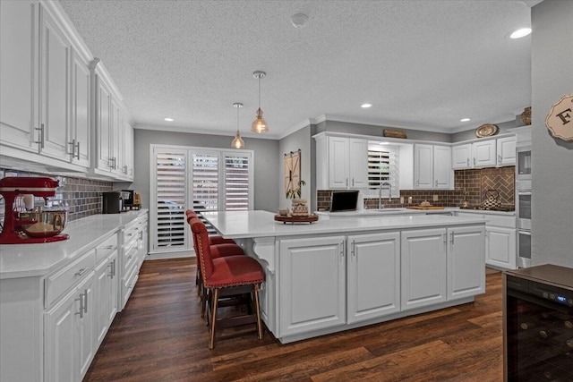 2004 Rice Dr, Levelland, TX 79336 - kitchen featuring white cabinetry, beverage cooler, light countertops, and decorative backsplash