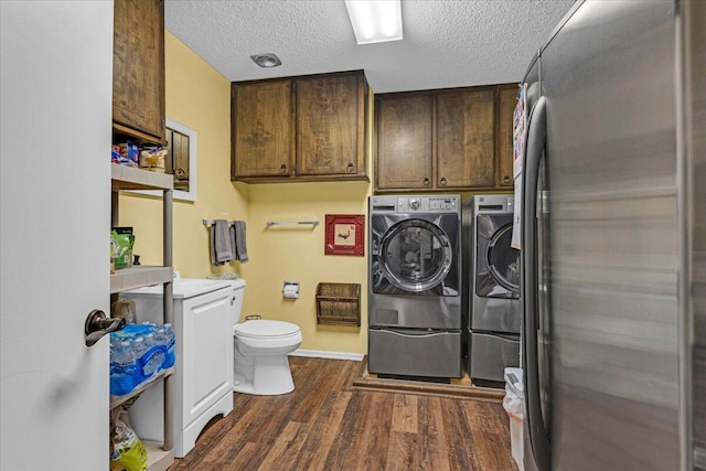 2004 Rice Dr, Levelland, TX 79336 - clothes washing area featuring a textured ceiling, washing machine and clothes dryer, baseboards, dark wood-type flooring, and laundry area
