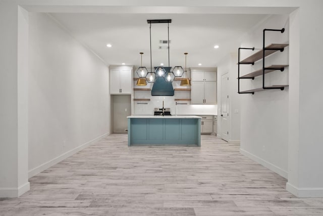 kitchen featuring open shelves, white cabinets, light countertops, and light wood-style floors