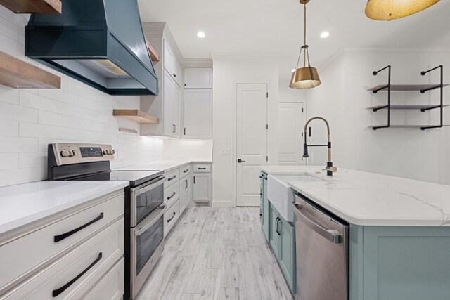 kitchen featuring open shelves, a sink, decorative backsplash, custom range hood, and appliances with stainless steel finishes