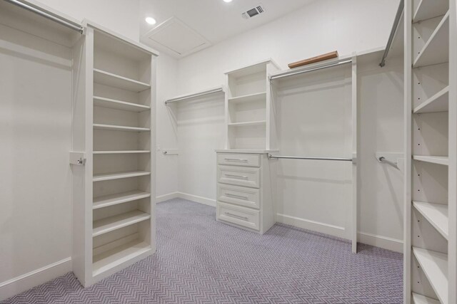 walk in closet with attic access, visible vents, and carpet floors