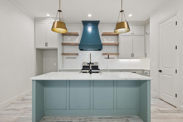 kitchen featuring open shelves, custom exhaust hood, stainless steel electric range, and a center island with sink