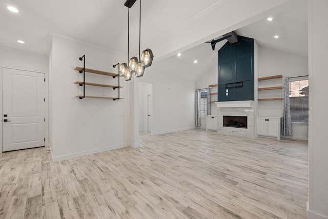 unfurnished living room with light wood finished floors, beamed ceiling, baseboards, and a high end fireplace