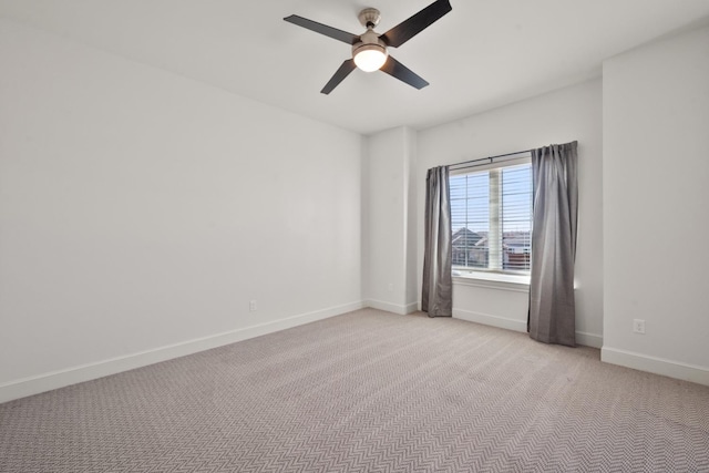 empty room with a ceiling fan, baseboards, and light carpet