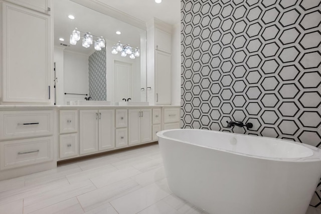 bathroom with a freestanding bath, ornamental molding, double vanity, recessed lighting, and tile walls