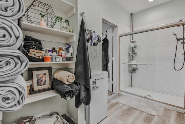 bathroom featuring hardwood / wood-style floors and a shower with shower door