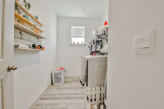 laundry area featuring light hardwood / wood-style floors and washing machine and dryer