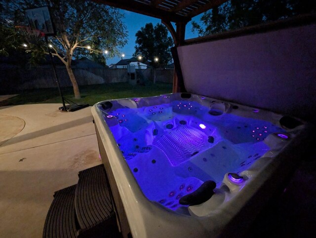 pool at twilight featuring a hot tub