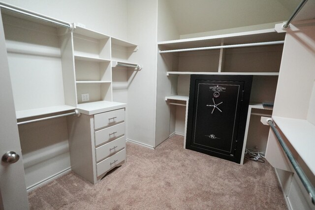 walk in closet featuring light colored carpet