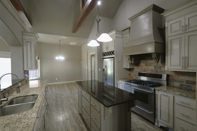 kitchen featuring sink, custom exhaust hood, dark stone countertops, pendant lighting, and stainless steel appliances