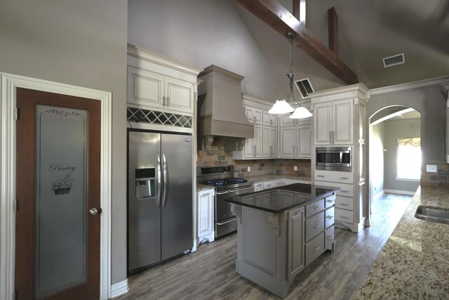 kitchen featuring premium range hood, hanging light fixtures, stainless steel appliances, high vaulted ceiling, and decorative backsplash