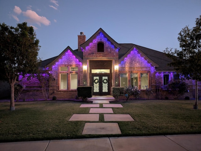 view of front of house with a lawn and french doors