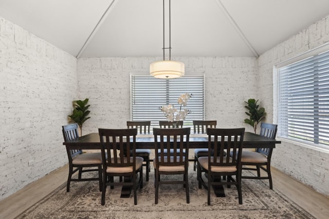 dining space with lofted ceiling and hardwood / wood-style floors