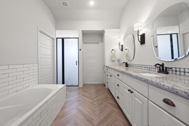 bathroom featuring parquet floors, vanity, and shower with separate bathtub