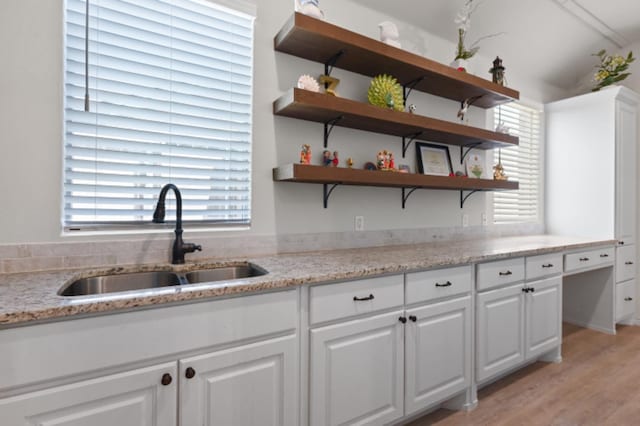 kitchen with white cabinetry, sink, light hardwood / wood-style flooring, and a healthy amount of sunlight