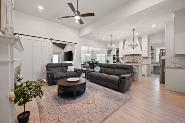 kitchen featuring premium range hood, sink, stainless steel double oven, gas stovetop, and a center island with sink