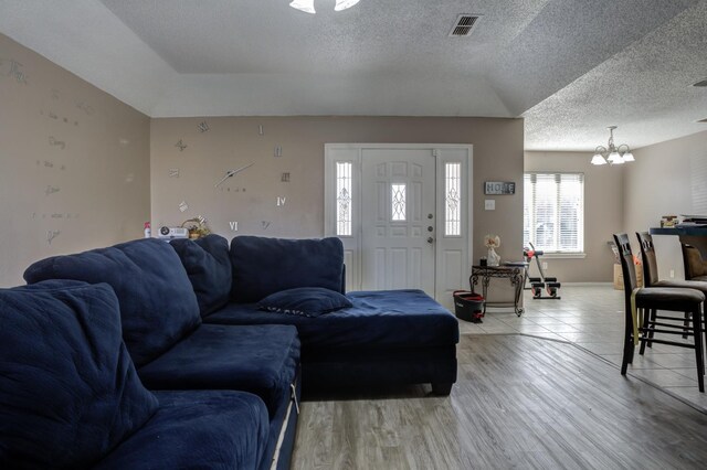 living room featuring hardwood / wood-style flooring, a chandelier, and a textured ceiling