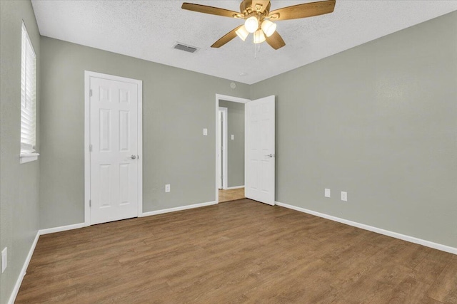 4802 54th St, Lubbock, TX 79414 - unfurnished bedroom with wood finished floors, baseboards, a textured ceiling, and a ceiling fan