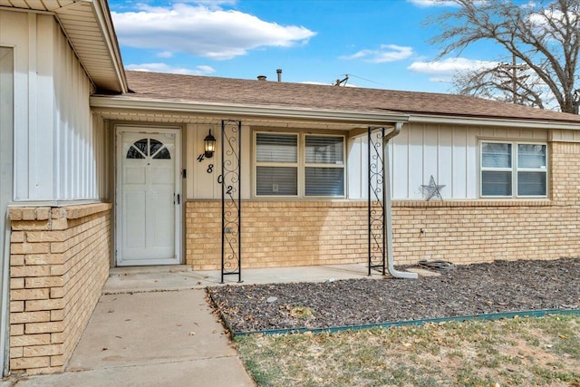 4802 54th St, Lubbock, TX 79414 - property entrance with brick siding, board and batten siding, and roof with shingles