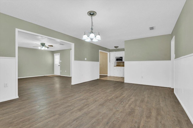 4802 54th St, Lubbock, TX 79414 - unfurnished living room with a chandelier, ceiling fan, dark wood-type flooring, and a wainscoted wall