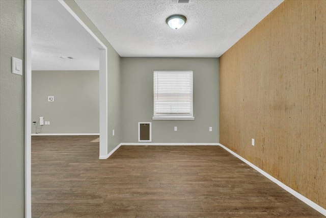 4802 54th St, Lubbock, TX 79414 - empty room with wood finished floors, a textured ceiling, baseboards, and heating unit