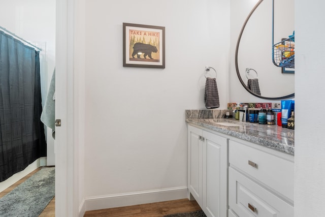 bathroom featuring vanity, baseboards, and wood finished floors