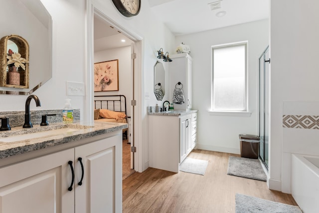 bathroom with two vanities, a sink, visible vents, and wood finished floors