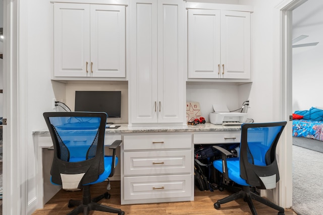 home office featuring light wood-type flooring and built in study area