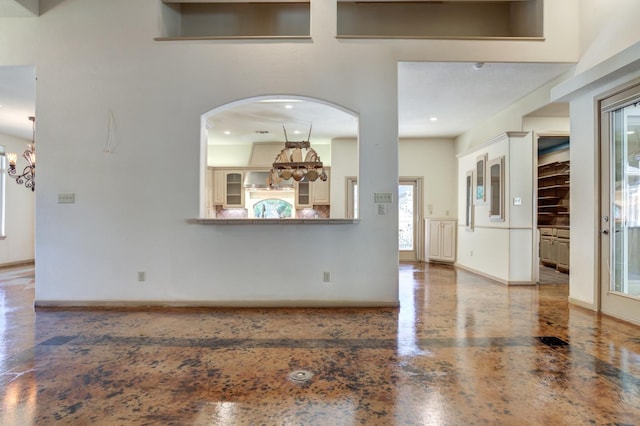 unfurnished living room featuring a notable chandelier