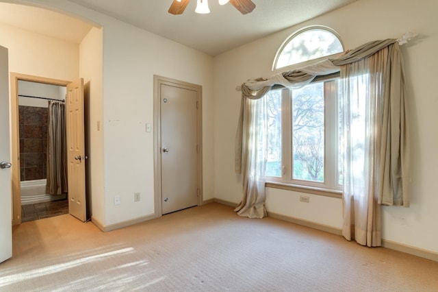 unfurnished room with ceiling fan and light carpet