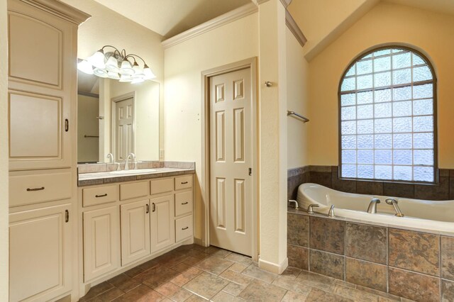 bathroom with lofted ceiling, vanity, and a relaxing tiled tub