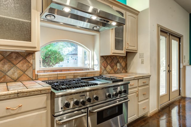 kitchen with french doors, double oven range, tile counters, range hood, and backsplash