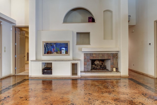 unfurnished living room featuring a high ceiling and a fireplace