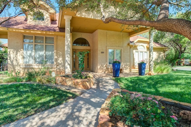 9202 Gardner Ave, Lubbock, TX 79424 - doorway to property with stucco siding, french doors, and a lawn