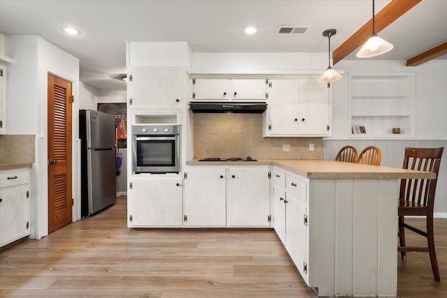 2713 59th St, Lubbock, TX 79413 - kitchen with stainless steel appliances, under cabinet range hood, a peninsula, open shelves, and white cabinets