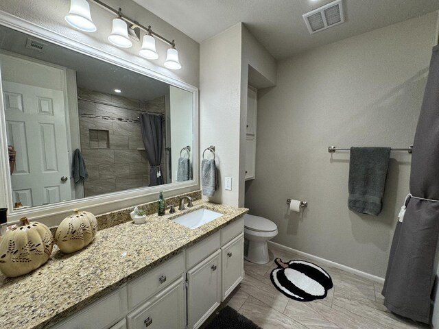 bathroom with walk in shower, vanity, and toilet