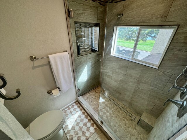 bathroom featuring an enclosed shower and toilet