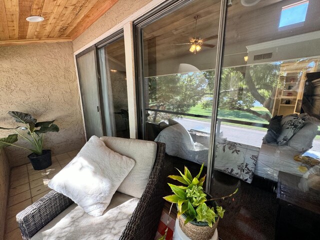 sunroom with ceiling fan, plenty of natural light, and wooden ceiling